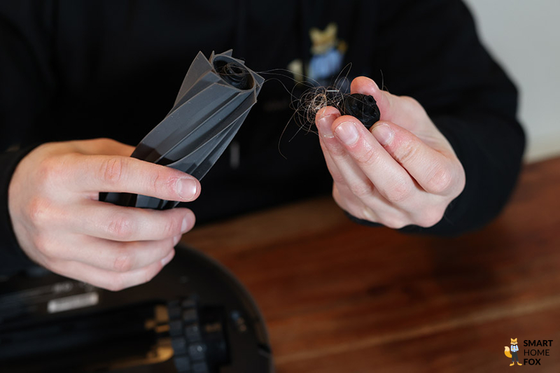 Haare werden aus der Gummibürste des Dreame L10s Pro entfernt.